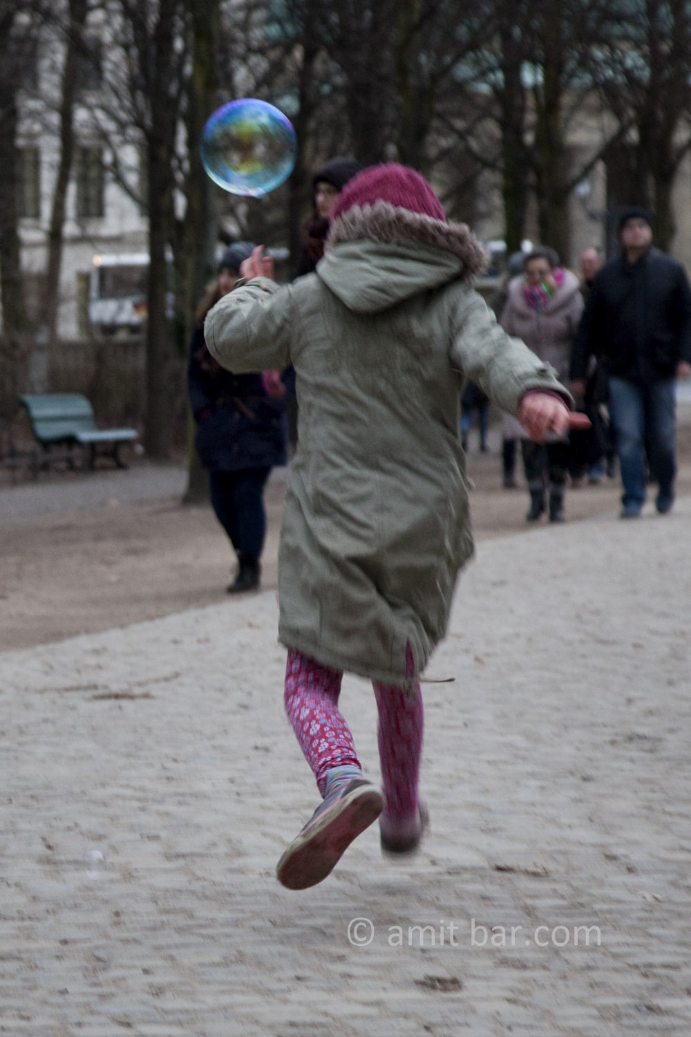 Berlin: Soap bubble. A girl is chasing a soap bubble