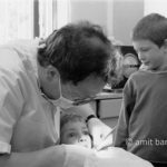 Big eyes: A boy on dentist 's chair, while his brother watching