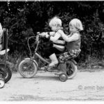 Biking: Three children biking on two bycicles