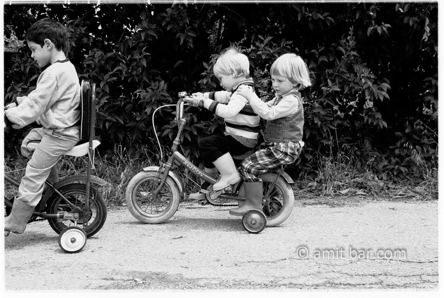 Biking: Three children biking on two bycicles