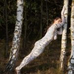 Birches grove III: A body-painting model is strolling among the white trunks of birch trees in De Achterhoek, The Netherlands