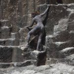 Black rock 2-I: body-painted model is climbing in a ancient quarry