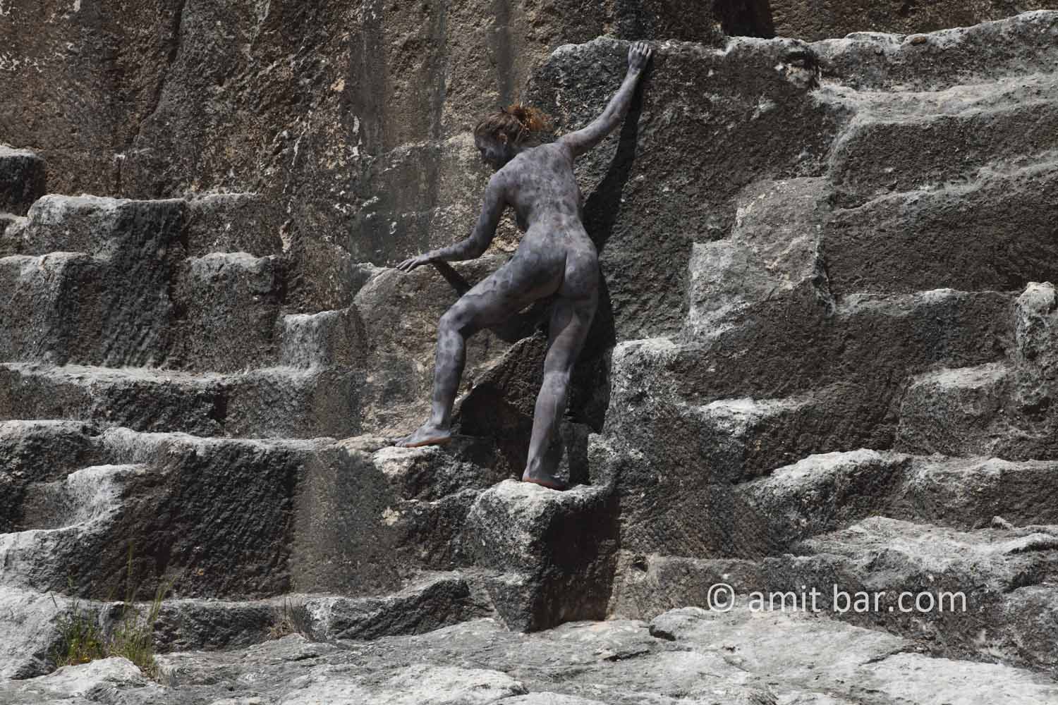 Black rock 2-I: body-painted model is climbing in a ancient quarry