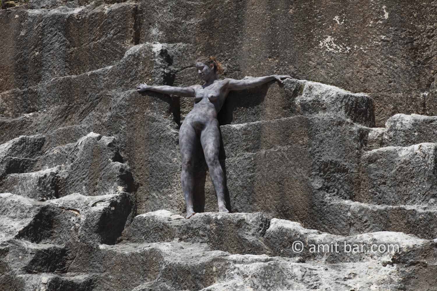 Black rock 2-II: Body-painted model is standing in a ancient quarry