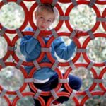 Climbing: A boy is climbing on a playing instrument