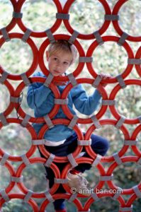 Climbing: A boy is climbing on a playing instrument