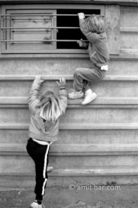 Climbing upwards: Two boys are climbing on a store wall
