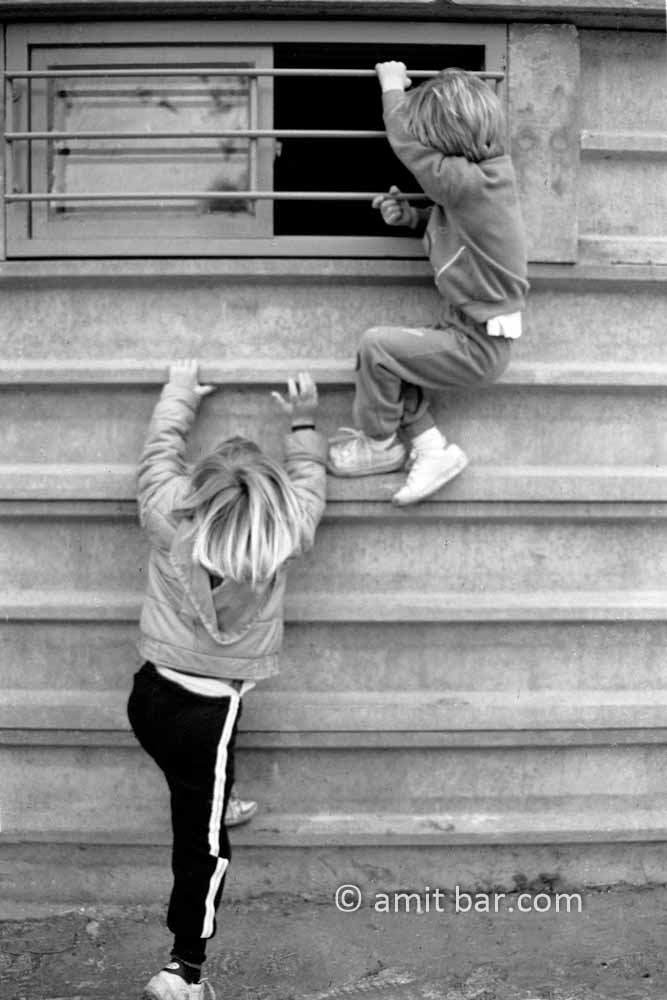 Climbing upwards: Two boys are climbing on a store wall