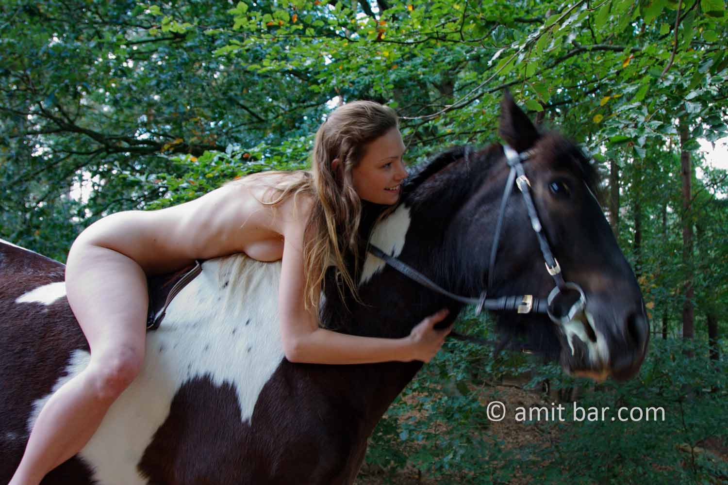 Cool down, boy!: Nude model on the back of a black and white horse