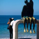 Couples: A sculpture couple looking to a real couple on the promenade of Puerto Vallarta, Mexico