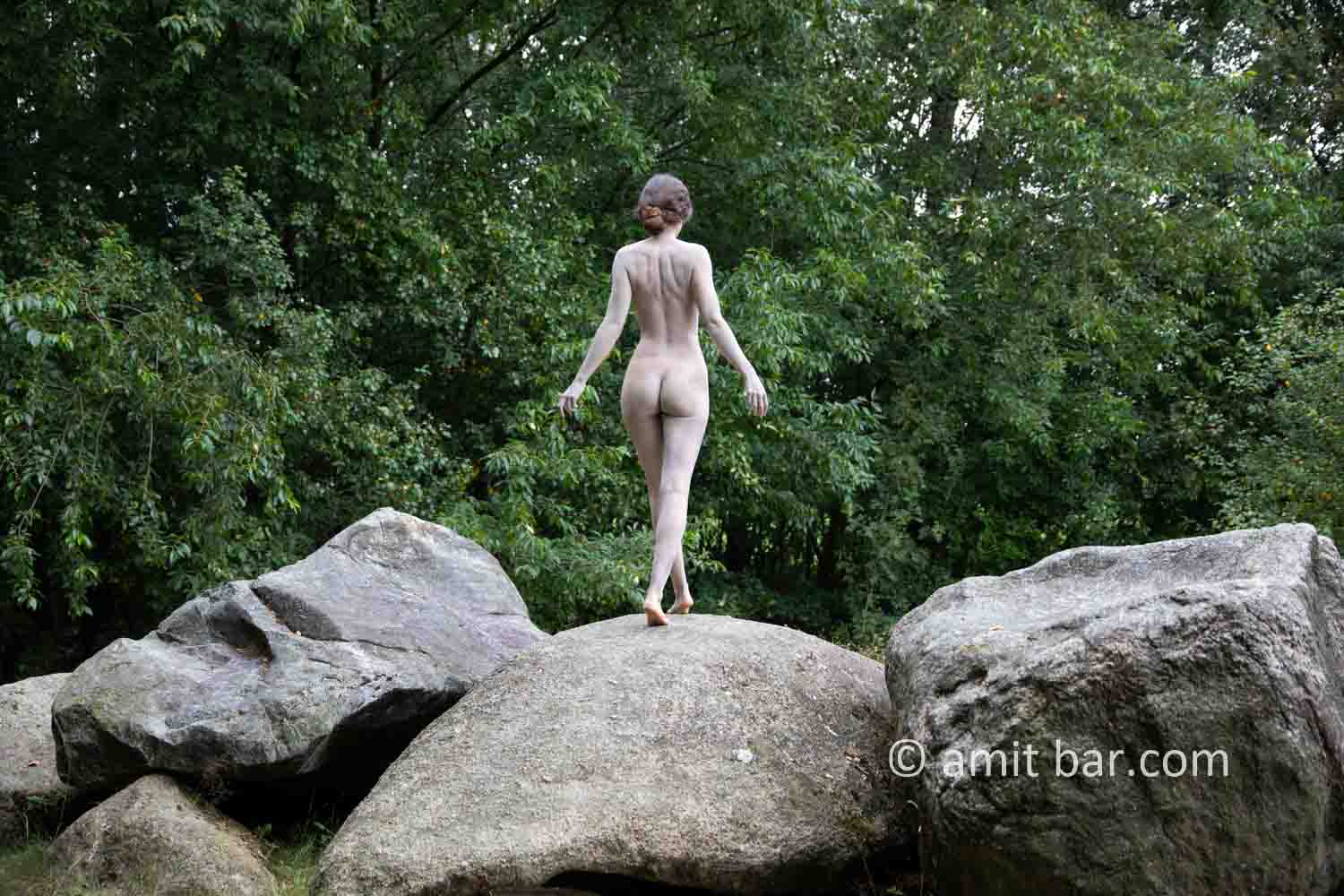 Dolmen woman body-painting II: body painted Elle is walking and laying around and on the huge stones of the dolmen at Drenthe, The Netherlands