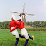 Double Dutch II: Two body-painted models as Dutch flag with a windmill in the background