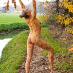 Ella autumn body-painting III: Body-painted Ella is dancing among the autumn leaves in nature