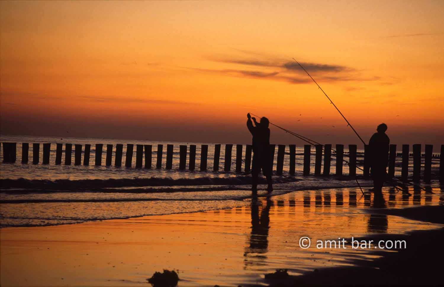 Fishermen at sunset: Fishermen are trying their last luck on the shore in The Netherlands