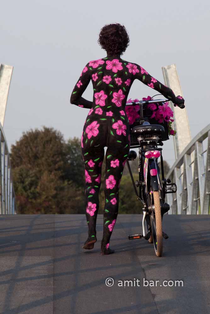 Flower girl II: Body-painted model with bicycle and pink flowers