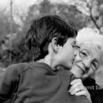 Grandmother and her grandson II: A gandmother is been kissed by her grandson