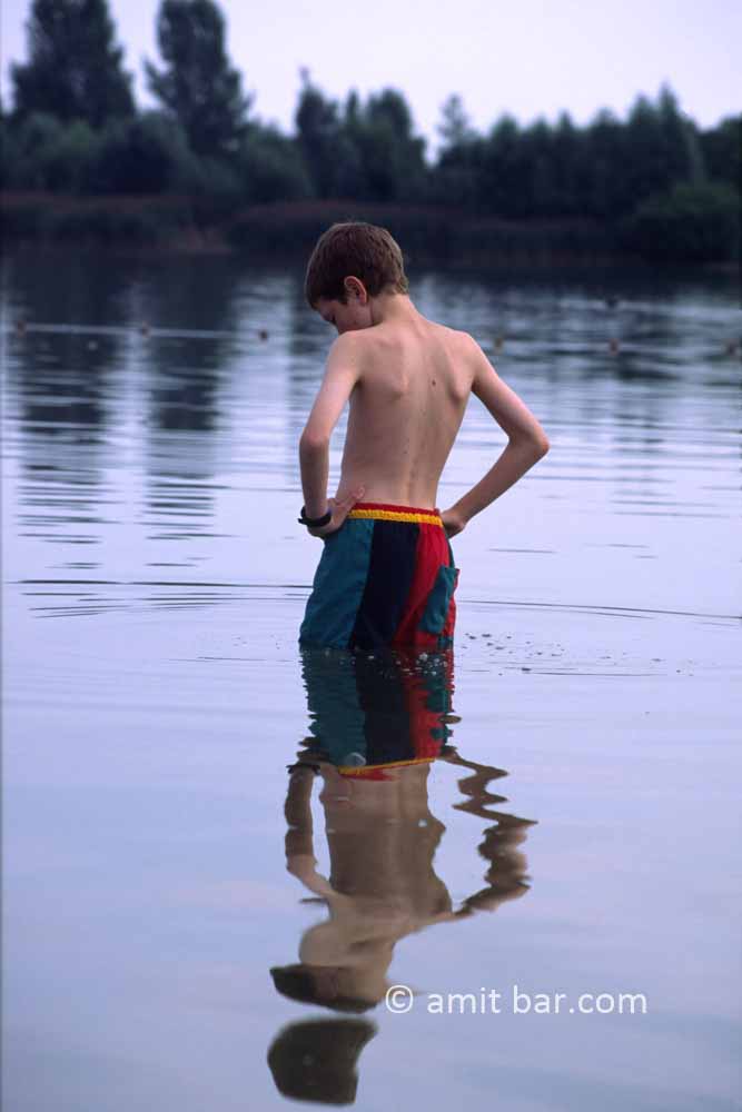 Having fun 2: A boy is standing in a lake