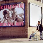 I make love safely, or I don't make love: A man with his toddler in a buggy is passing besides the billboard: "I make love safely, or I don't make love".