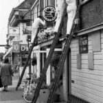 On the ladder: Three painters are working on ladders beside the Interflora courier. Doetinchem, The Netherlands