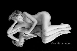 On the mirror: Nude model lying on a mirror
