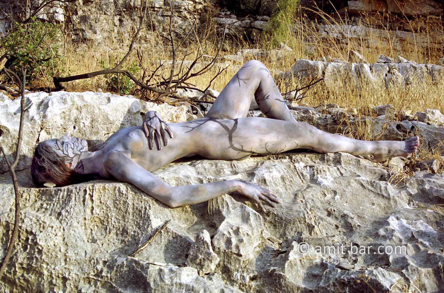 On the rocks I: Body-painted model in the Israeli nature