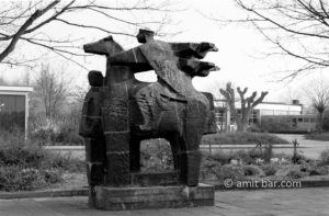 Parable: A trimmed tree is standing behind the sculpture of St. Ludger in Doetinchem