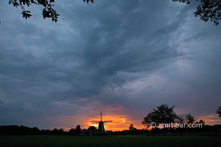 Rain clouds, sunset and windmill