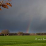 Rainbow above farmhouse