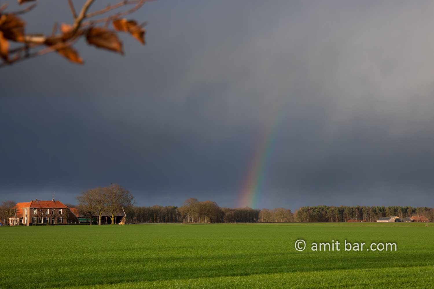 Rainbow above farmhouse