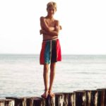 Ready to jump I: A boy is standing on pillars at the sea