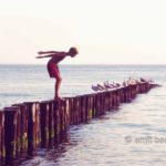 Ready to jump II: A boy is preparing to jump in the sea