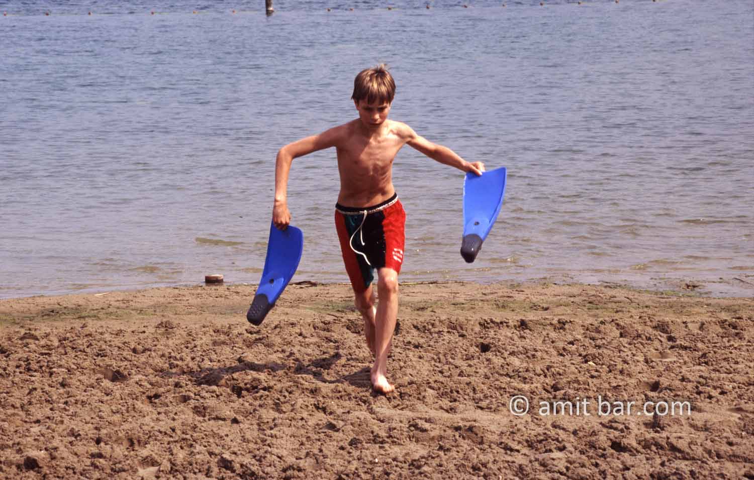 Swim fins: A boy is running with his swim fins