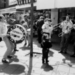 Van Faren: A street ensemble is playing while a child is watching them