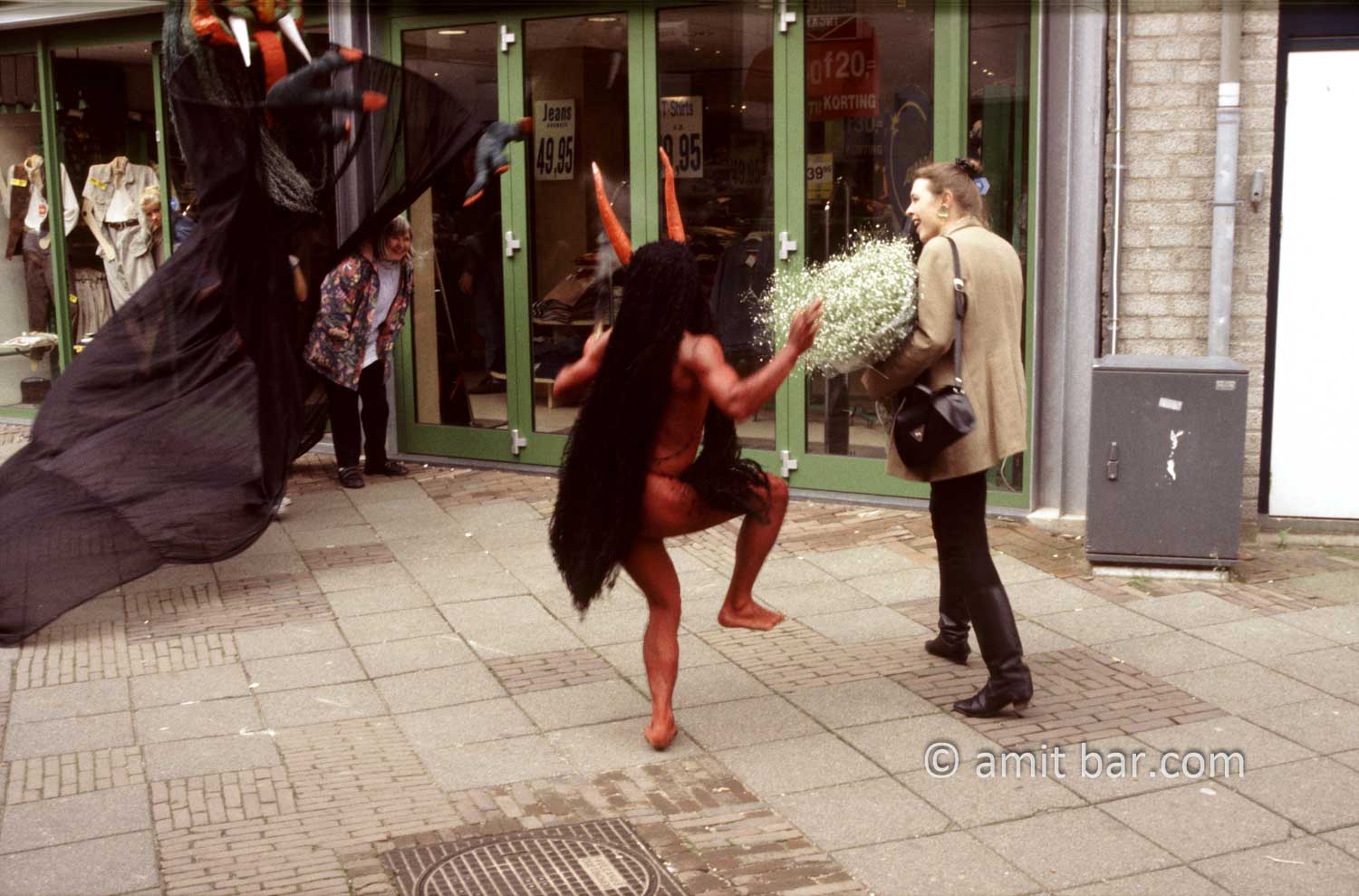 Who's afraid of the Devil II: An actor dressed as a devil is chasing a girl on street theater festival in Doetinchem, The Netherlands